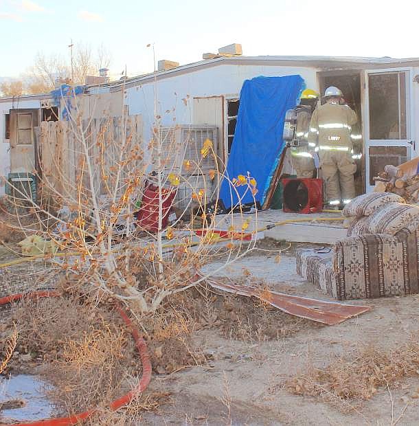 Firefighters enter the front door of a trailer Wednesday after knocking down flames.