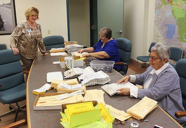 From left, County Clerk Kelly Helton, Renae Paholke and Nyla Howell open absentee envelopes on Thursday. The ballots will be processed on Tuesday.