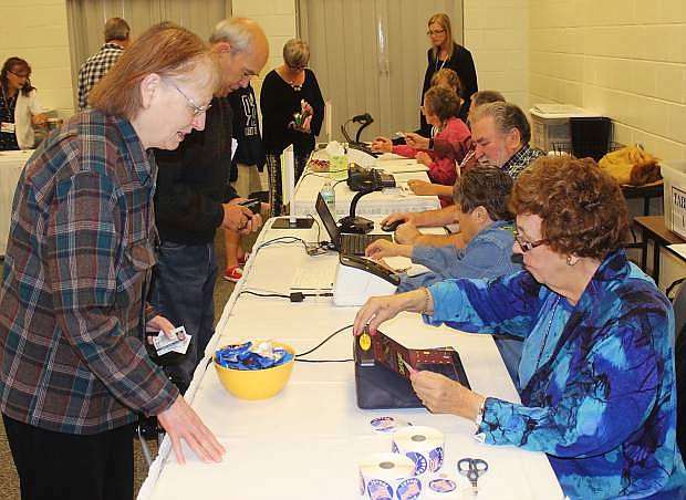 Election volunteer Simmie Travis, right, helps a voter Tuesday morning.