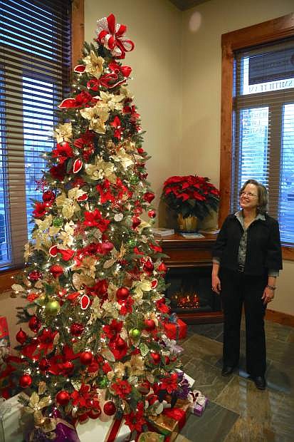 Marianne Rhoads, a senior paralegal at Rutledge Law Center admires a Christmas tree in their lobby decorated by Carson City resident Charles Adams. Adams, who has photographed many celebreties and was Muhammad Ali&#039;s personal photographer, calls his design the &quot;Magic of Christmas.&quot;