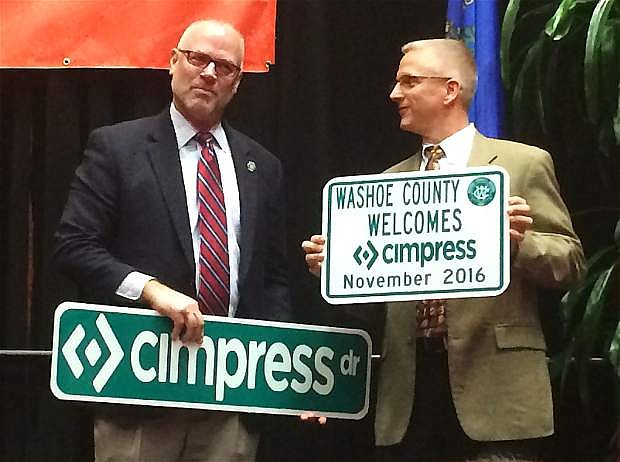 Washoe County Manager John Slaughter, left, presents a road sign to Cimpress Vice President Plant Development Larry Reid during a press conference Nov. 7 to announce the printing company&#039;s plans to open a plant in Reno. The county renamed the road leading to the plant off Red Rock Road, Cimpress Drive to welcome the company.