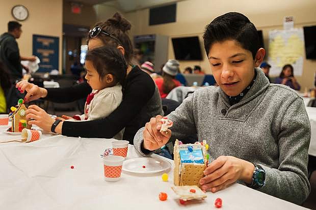 Juan Brena, 14 creates a gingerbread house during the Make Your Own Gingerbread House event at the Carson City Library on Sunday in Carson City.