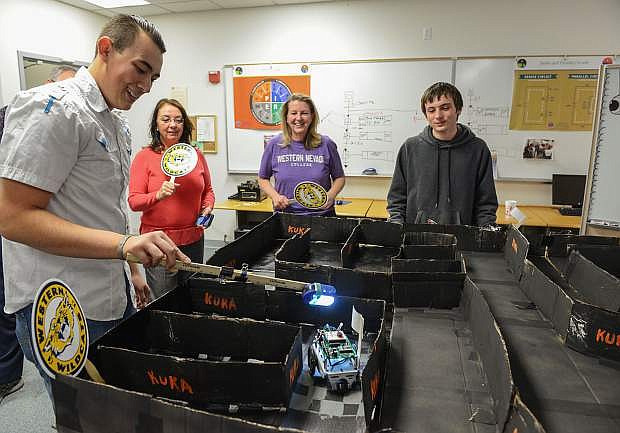 Luis Rowell brings his flashlight-guided robot to the finish of a maze during the Western Nevada College Robot Olympics, part of the school&#039;s Jump Start College program. From left are, Linda Whitehill, WNC community education coordinator, Emily Howarth, WNC professor of electronics and industrial technology and student Aaron Fischer.