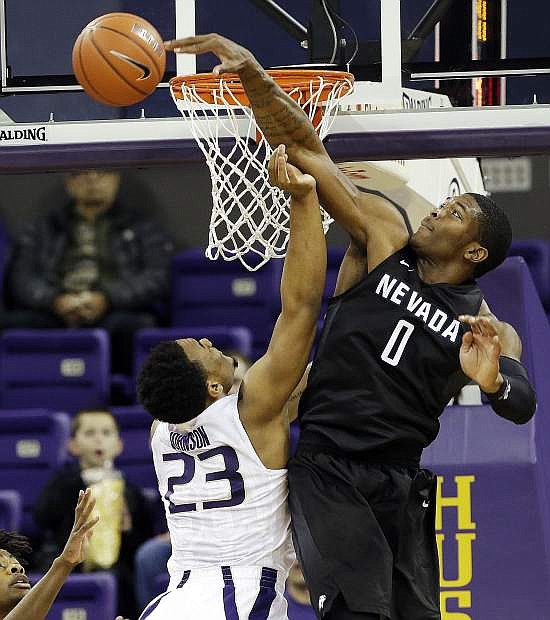 Nevada&#039;s Cameron Oliver (0) blocks a shot by Washington&#039;s Carlos Johnson in the first half of an NCAA college basketball game Sunday, Dec. 11, 2016, in Seattle. (AP Photo/Elaine Thompson)