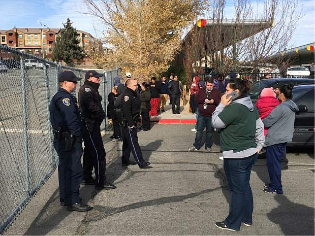 Parents wait outside Hug High School after a shooting on campus caused a lockdown, Wednesday, Dec. 7, 2016, in Reno, Nev.  (Andy Barron/The Reno Gazette-Journal via AP)