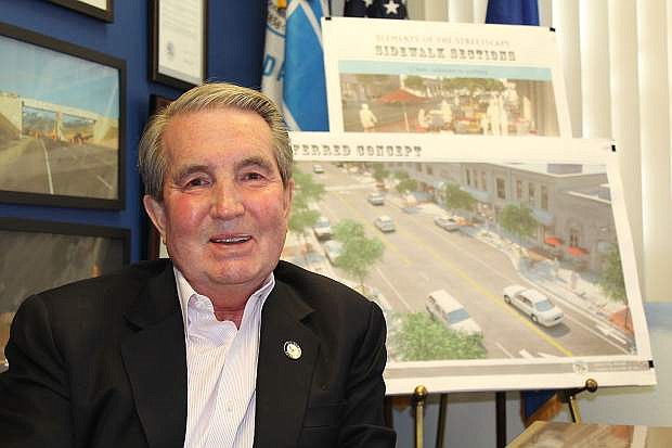 Mayor Robert Crowell sits in front of the conceptual plans for the downtown, now completed.