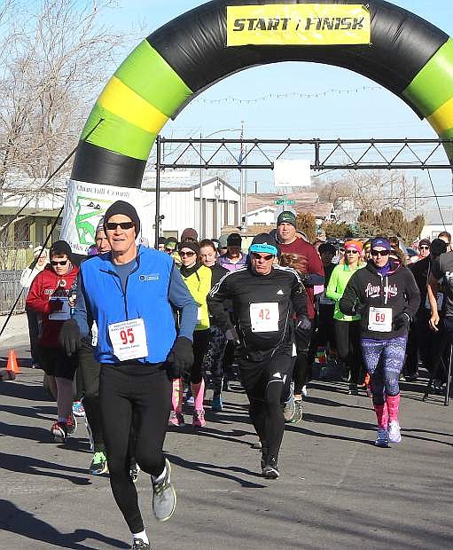 Runners take off from the starting line during the annual New Year&#039;s Day 5K Fun Run/Walk in 2015.
