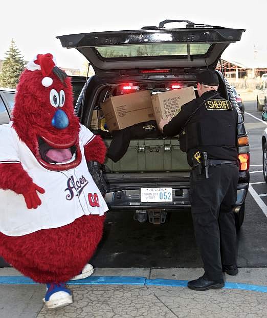 Ace&#039;s mascot &#039;Archie&#039; helps CCSO Deputy Dan Jones load the back of his vehicle Friday at Greater Nevada Credit Union.
