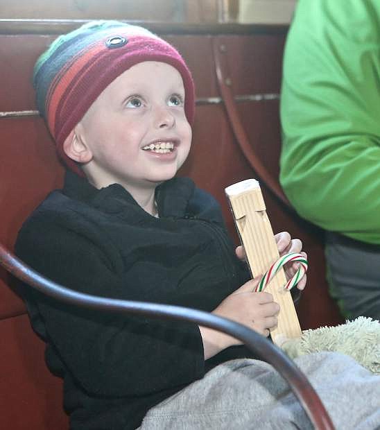 Diagnosed with Neuroblastoma in April 2015, 4-year-old Logan Smith shows a big smile to Santa after receiving a candy cane and train whistle Saturday at the Nevada State Railroad Museum.
