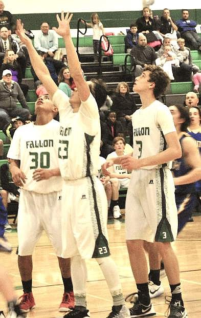 Christian Nemeth (middle) shoots for the basket under guard of Craig Smith (left) and Hayden Strasdin during the Greenwave&#039;s home game against South Tahoe.
