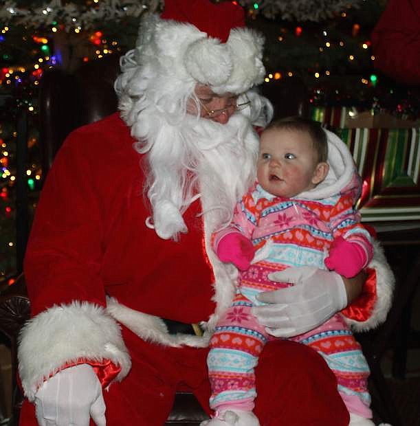 At 8 months of age, Riley Bryant is in awe of Santa at the tree lighting on Friday.