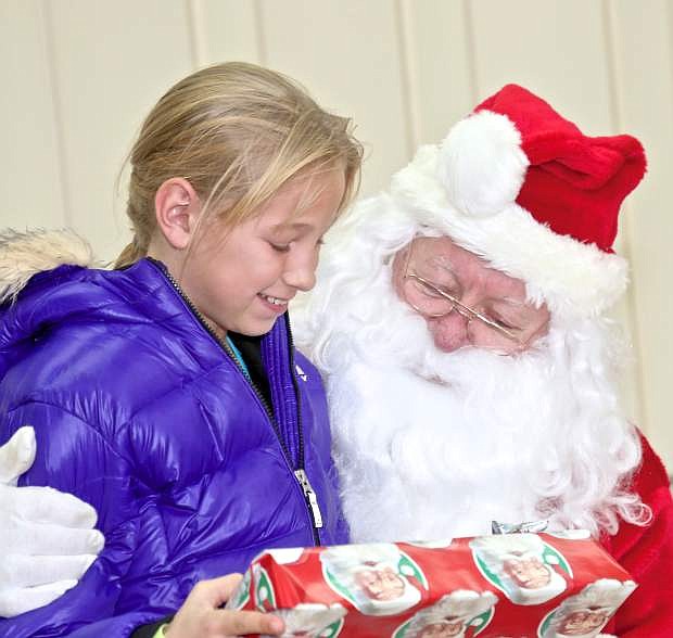 10-year-old Darby Larsen smiles as she chats with Santa Saturday at Carson Middle School.