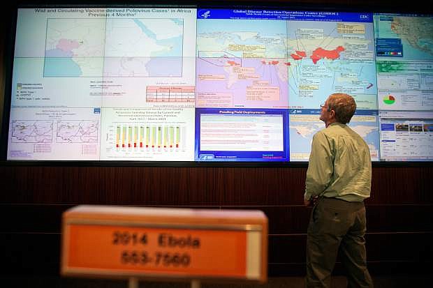 FILE- In this Aug. 5, 2014 file photo, Steve Monroe, deputy director of the National Center for Emerging and Zoonotic Infectious Diseases at the U.S. Centers for Disease Control and Prevention, looks over a map showing global health issues under the agency&#039;s surveillance from their Emergency Operations Center in Atlanta. In the space of just a few months, the reputations and approval ratings of the Centers for Disease Control and Prevention, Secret Service, as well as the Veterans Administration, have been seen a decline. (AP Photo/David Goldman, File)
