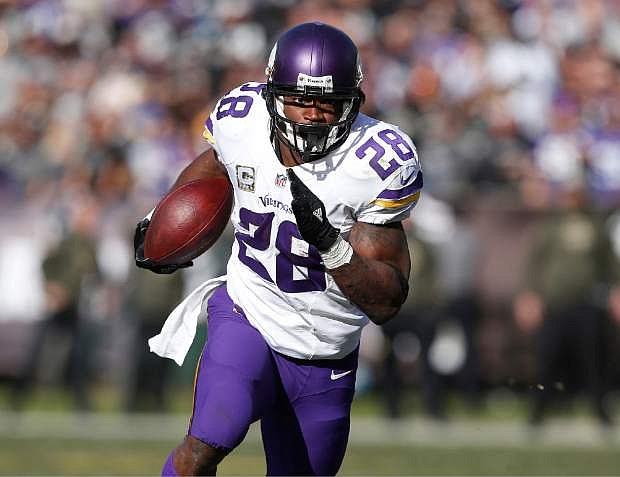 FILE - In this Nov. 15, 2015, file photo, Minnesota Vikings running back Adrian Peterson carries against the Oakland Raiders during an NFL football game in Oakland, Calif.  Peterson is a unanimous choice for the 2015 Associated Press NFL All-Pro Team.  (AP Photo/Beck Diefenbach, File)