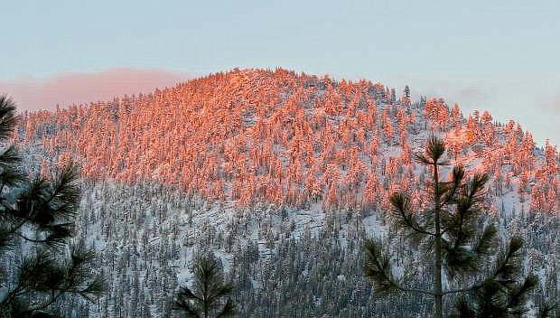 The snow-capped Carson Range is kissed by the setting sun Wednesday evening near Spooner Summit.