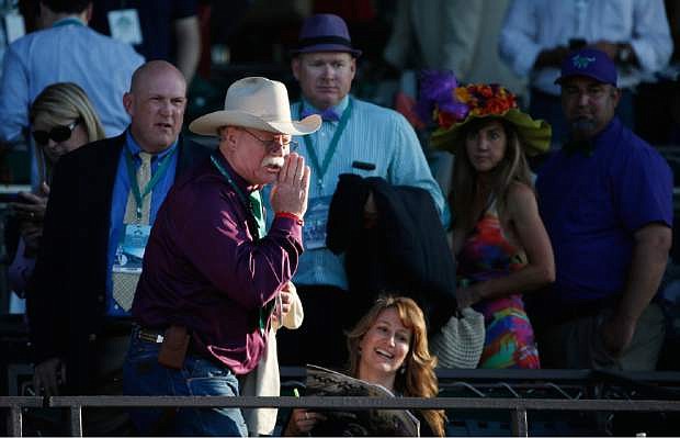 California Chrome co-owner Steve Coburn calls from the grandstand at Belmont Park after his horse finished fourth in the Belmont Stakes horse race, Saturday, June 7, 2014, in Elmont, N.Y. (AP Photo/Kathy Willens)