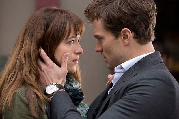 In this image released by Universal Pictures and Focus Features, Dakota Johnson, left, and Jamie Dornan appear in a scene from the film, &quot;Fifty Shades of Grey.&quot;  (AP Photo/Universal Pictures and Focus Features)