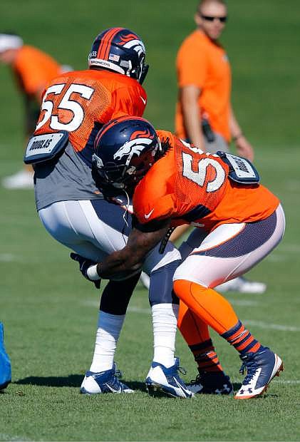 Denver Broncos&#039; Danny Trevathan runs a drill against Lerentee McCray (55) during NFL football training camp on Tuesday, Aug 12, 2014, in Englewood, Colo.  Trevathan was injured later in practice. (AP Photo/Jack Dempsey)