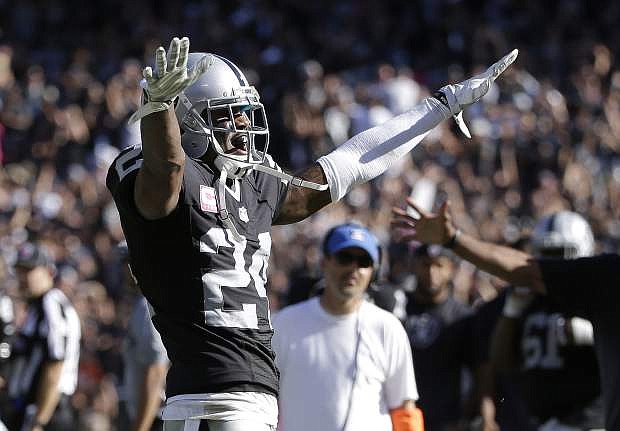 Oakland Raiders cornerback Charles Woodson (24) reacts after intercepting Denver Broncos quarterback Peyton Manning during the second half of an NFL football game in Oakland, Calif., Sunday, Oct. 11, 2015. (AP Photo/Marcio Jose Sanchez)