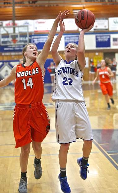 Carson&#039;s Lauren Lemburg drives to the hoop against Douglas&#039; Madison Smalley Friday night at Morse Burley Gym.