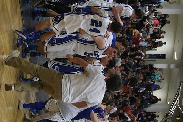 Classmates storm the court as the basketball team celebrates their overtime win against Douglas on Tuesday night.