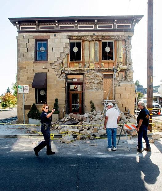 A Napa police sergeant asks spectators to move further from the damaged Vintner&#039;s Collective tasting room in Napa, Calif., following an earthquake Sunday, Aug. 24, 2014. Officials in the city of Napa say 15 to 16 buildings are no longer inhabitable after Sunday&#039;s magnitude-6.0 earthquake, and there is only limited access to numerous other structures. (AP Photo/Noah Berger)