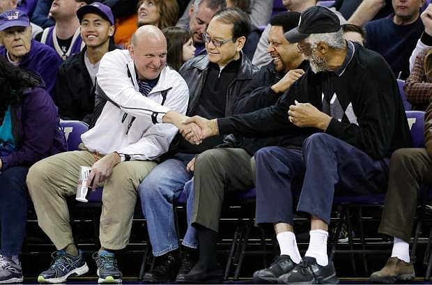 FILE - In this Jan. 25, 2014, photo, then-Microsoft CEO Steve Ballmer, left, shakes hands with former NBA players Bill Russell, right, and &quot;Downtown&quot; Freddie Brown as Omar Lee looks on during an NCAA college basketball game between Washington and Oregon State in Seattle. Ballmer is officially the new owner of the Los Angeles Clippers. The team says the sale closed Tuesday, Aug. 12, 2014,  after a California court confirmed the authority of Shelly Sterling, on behalf of the Sterling Family Trust, to sell the franchise. (AP Photo/Elaine Thompson, File)