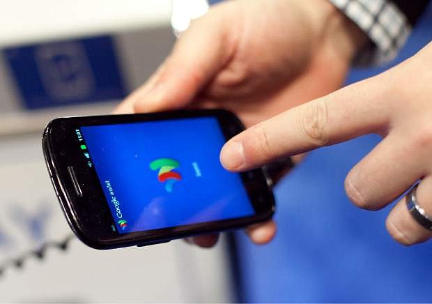 FILE - In this Jan. 17, 2012 file photo, a person tries a smartphone loaded with Google Wallet at the National Retail Federation in New York. Apple Pay has gotten a lot of attention in recent weeks, but there are lots of other mobile-payment systems. Google Wallet uses a similar wireless technology called NFC, or near-field communication. (AP Photo/Mark Lennihan, File)
