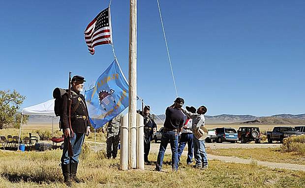 Re-enactors, members of the Nevada National Guard and Western Shoshone tribe raise an American flag and Western Shoshone flag Saturday during the opening of the interpretive trail at the fort at Fort Ruby.