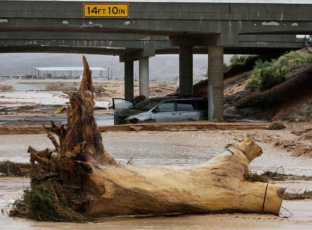 A minivan is seen in floodwaters beneath Interstate 15 in Moapa, Nev., Monday, Sept. 8, 2014. The National Weather Service has issued a flash flood emergency for the area. (AP Photo/John Locher)