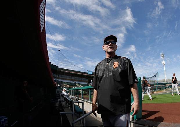 San Francisco Giants manager Bruce Bochy talks with fans as he leaves the field following a spring training baseball practice Thursday in Scottsdale, Ariz.