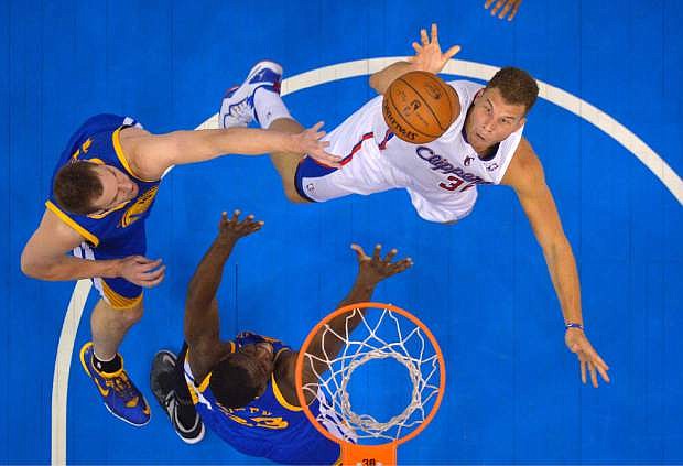 Los Angeles Clippers forward Blake Griffin, right, puts up a shot as Golden State Warriors forward David Lee, left, and forward Draymond Green defend during the first half in Game 7 of an opening-round NBA basketball playoff series, Saturday, May 3, 2014, in Los Angeles. (AP Photo/Mark J. Terrill)