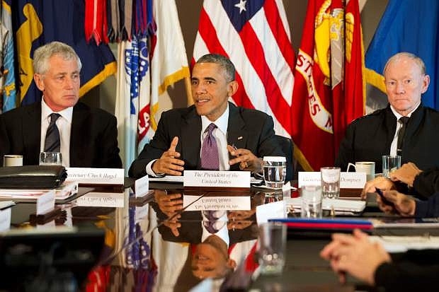 FILE - In this Oct. 8, 2014 file photo, President Barack Obama, flanked by Defense Secretary Chuck Hagel, left, and Joint Chiefs Chairman Gen. Martin Dempsey, speaks to the media at the conclusion of a meeting with senior military leadership, at the Pentagon. Defense Secretary Hagel is resigning from the Obama Cabinet Monday. (AP Photo/Jacquelyn Martin)