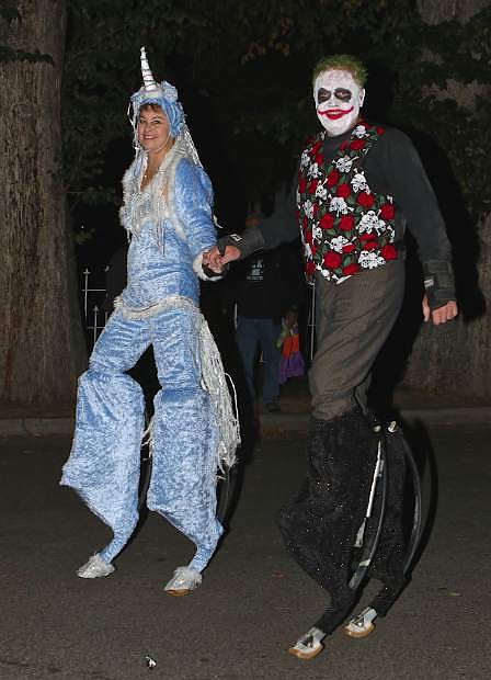 Dawn Port (unicorn) and Bob Nye (Joker) walk on stilts down Mountain Street near the Governor&#039;s Mansion Friday night.