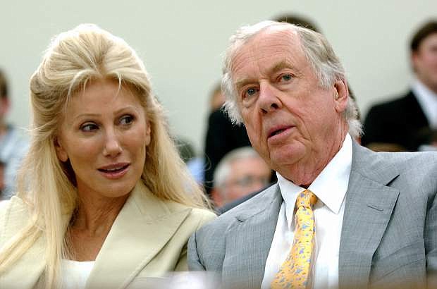 FILE - In this July 25, 2006, file photo, Oklahoma energy tycoon T. Boone Pickens, right, with his wife, Madeleine, appear at a House Energy and Commerce subcommittee hearing on Capitol Hill in Washington. A federal lawsuit accuses Madeleine Pickens, the ex-wife Pickens, of racial discrimination at her rural Nevada dude ranch. (AP Photo/Dennis Cook, File)