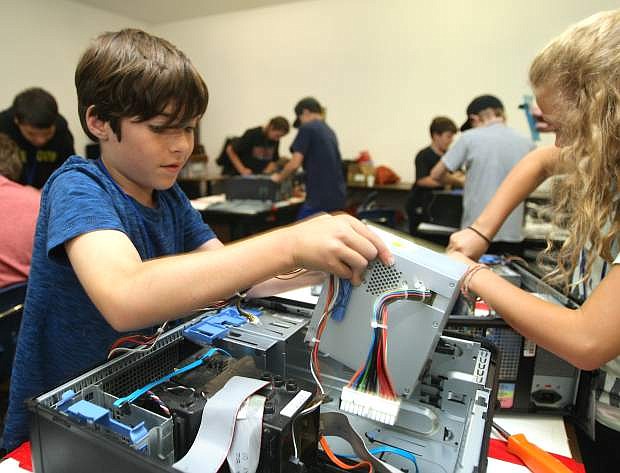 David Hochgurtel, 10, removes a power supply unit while disassembling a computer at TechCamp on Tuesday. The two-week camp is presented by Computer Corps and teaches youth about a variety of computer topics, including, assembly, operations, concepts, operating system fundamentals and internet safety. For more information about TechCamp call 883-2323 or visit ComputerCorps.org.