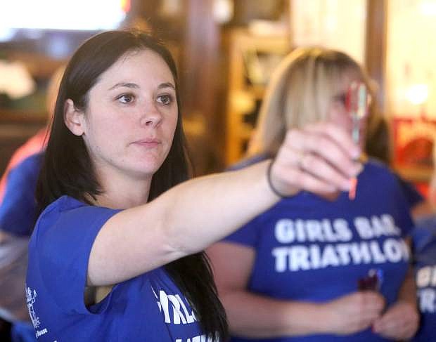 Kathleen &quot;Kat&quot; Davis concentrates on her dart game, the third and final event of the Girls Bar Triathlon. Held on Martin Luther King day, the triathlon is an annual fundraiser to benefit local charities.