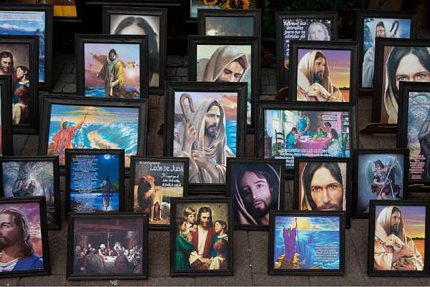 Pictures of Jesus are displayed for sale in the main plaza of Xochimilco, on the southern edge of Mexico City, Wednesday, May 7, 2014. In Xochimilco, busy markets stand side by side with colonial churches, and children ride to school in boats pushed by poles, along a network of canals and floating gardens that date to pre-hispanic times. The popular tourist destination was declared a UNESCO world heritage site in 1987. (AP Photo/Rebecca Blackwell)