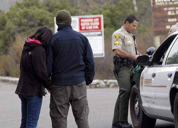 Unidentified family members wait for a group of missing hikers at the entrance of Eaton Canyon, in Pasadena, Calif. on Monday, Nov. 10, 2014. Rescue crews were searching on foot and by air early Monday for at least 15 hikers from a church group who didn&#039;t return from a weekend hike in a Southern California nature preserve. (AP Photo/Nick Ut)