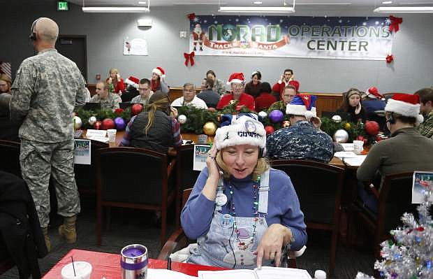 Volunteer Patty Shook takes a phone call from a child asking where Santa is and when he will deliver presents to her home, inside a phone-in center during the annual NORAD Tracks Santa Operation, at the North American Aerospace Defense Command, at Peterson Air Force Base, Colo. Patty and her husband, Bryan, who is retired from the Air Force, have been volunteering at NORAD each Christmas Eve for five years, fielding calls from children from all over the world eager to hear about Santa&#039;s progress.