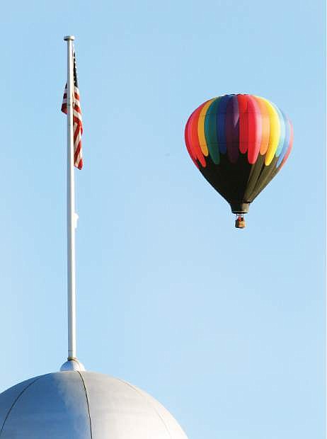 A hot-air balloon floats past the Legislature building during the the ReMax/Nevada Day balloon launch on Saturday.