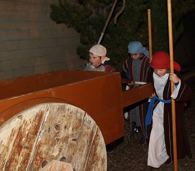 Eric Billings, 9, Matthew Scharadin, 8, and Zachary Laaker, 9,  push a cart at the living nativity Saturday night at First United Methodist Church.