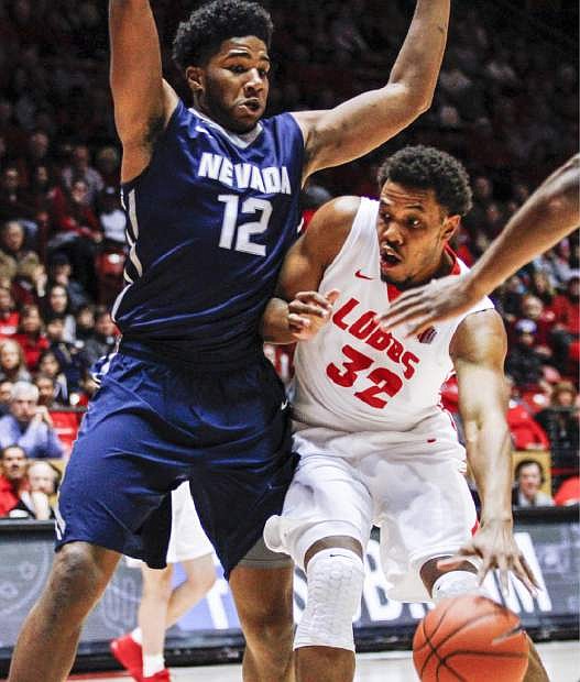 New Mexico&#039;s Tim Williams (32) drives to the basket as Nevada&#039;s Elijah Foster (12) defends during the first half an NCAA college basketball game Wednesday, Dec. 30, 2015, in Albuquerque, N.M. (AP Photo/Juan Labreche)