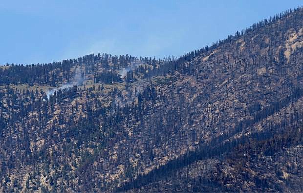 Small fires smolder on the south side of Mt. Charleston at Trout Canyon, Tuesday, July 16, 2013, near Pahrump, Nev. A sweeping wildfire that threatened mountain homes near Las Vegas was 80 percent contained, while crews prepared Tuesday to allow a final wave of residents back to neighborhoods evacuated 11 days ago. (AP Photo/Julie Jacobson)