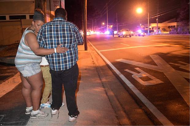 Bystanders wait down the street from a multiple shooting at the Pulse nightclub in Orlando, Fla., Sunday, June 12, 2016. A gunman opened fire at a nightclub in central Florida, and multiple people have been wounded, police said Sunday.  (AP Photo/Phelan M. Ebenhack)