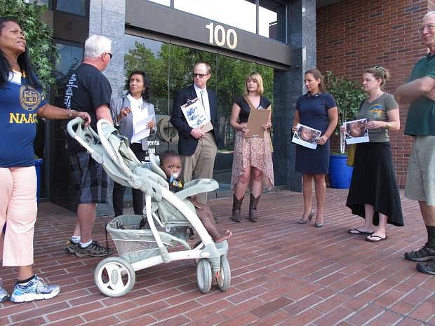 Pat Gallimore, left, second vice president of the Reno-Sparks NAACP, with her grandson, Boston; Theresa Navarro, third from left, chairwoman of the Nevada Progressive Alliance of Nevada; and Bob Fulkerson, center, PLAN&#039;s state director, were among those who delivered a letter to the U.S. attorney&#039;s office in Reno, Nev., Monday, Aug. 25, 2014, calling for the firing of the Ferguson police officer who shot Michael Brown in Missouri and urging Attorney General Eric Holder to launch a nationwide investigation of police brutality and harassment in minority communities. (AP Photo/Scott Sonner)