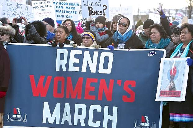 A group of Native American women hold a banner in downtown Reno Saturday morning.