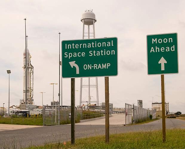 Signs stand outside launch Pad-OA near the Orbital Sciences Corporation Antares rocket, left, with its Cygnus cargo spacecraft aboard, at the Mid-Atlantic Regional Spaceport (MARS) at the NASA Wallops Flight Facility on Monday, Sept. 16, 2013 in Wallops Island, Virginia. NASA&#039;s commercial space partner, Orbital Sciences Corporation, is targeting a Sept. 18 launch for its demonstration cargo resupply mission to the International Space Station. (AP Photo/NASA, Bill Ingalls)