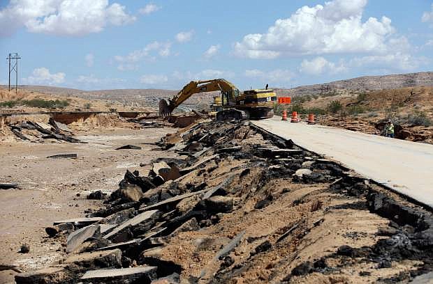 Construction crews work on a flood damaged area of Interstate 15 Tuesday, Sept. 9, 2014, near Moapa, Nev. Flood damage caused the closure of the interstate which is the main road between Las Vegas and Salt Lake City. (AP Photo/John Locher)