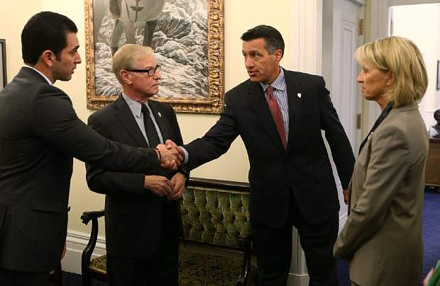 Nevada Senators, from left, Ruben Kihuen, David Parks and Barbara Cegavske talk with Gov. Brian Sandoval, right center, at the Capitol, in Carson City, Nev., on Wednesday, Sept. 10, 2014. Sandoval called lawmakers into a special session to examine a deal that gives $1.3 billion in tax breaks and other incentives to bring Tesla Motors to Nevada. (AP Photo/Cathleen Allison)